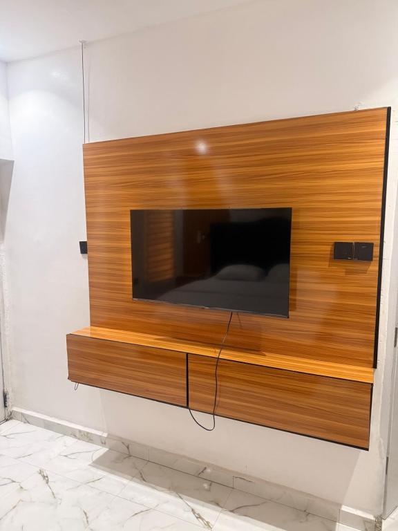 a tv on a wall in a room at De Rex Luxury Apartment in Akwa