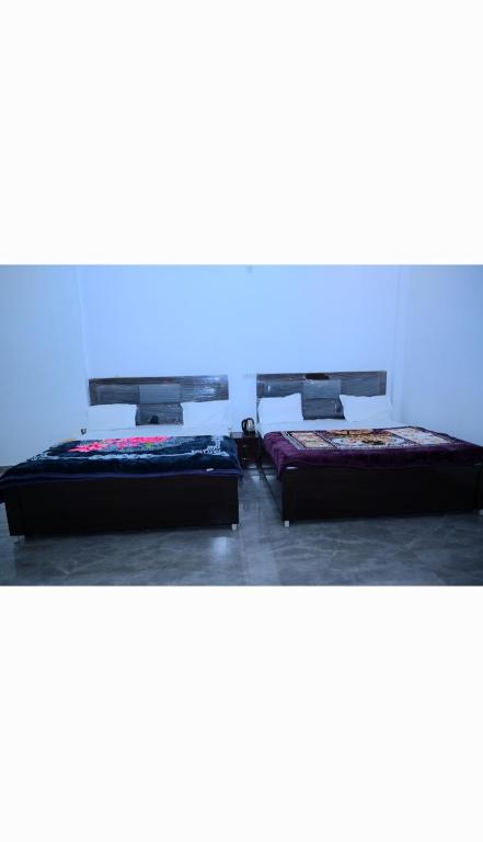 two beds sitting next to each other in a room at Shree Hanumantam homestay in Ayodhya
