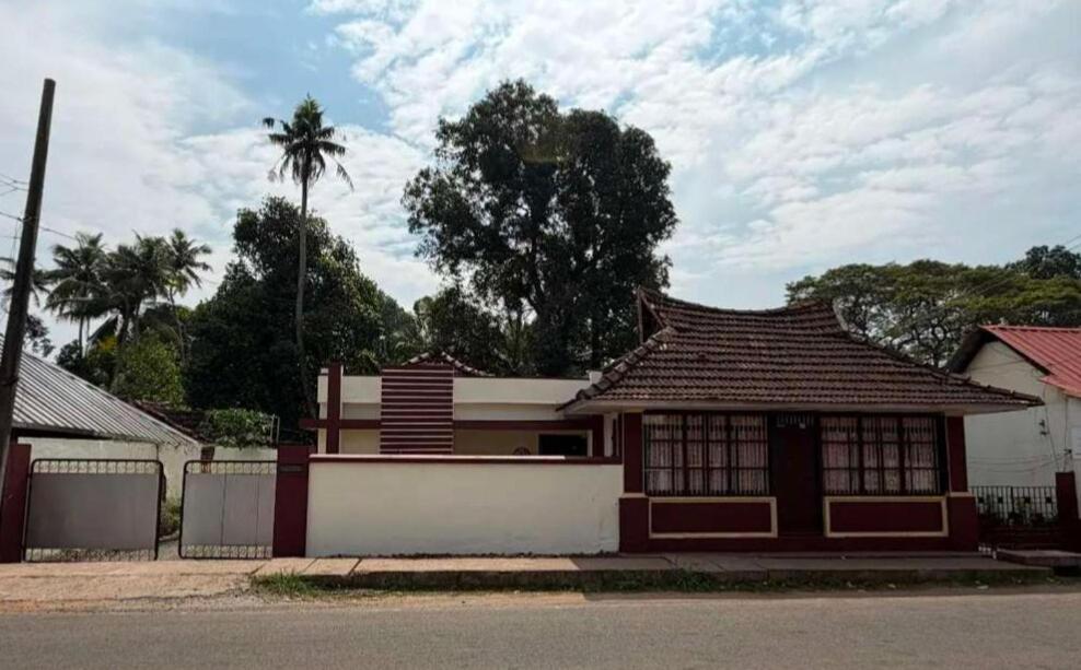 a building with a roof on the side of a street at Le Stories Heritage Home in Kottayam