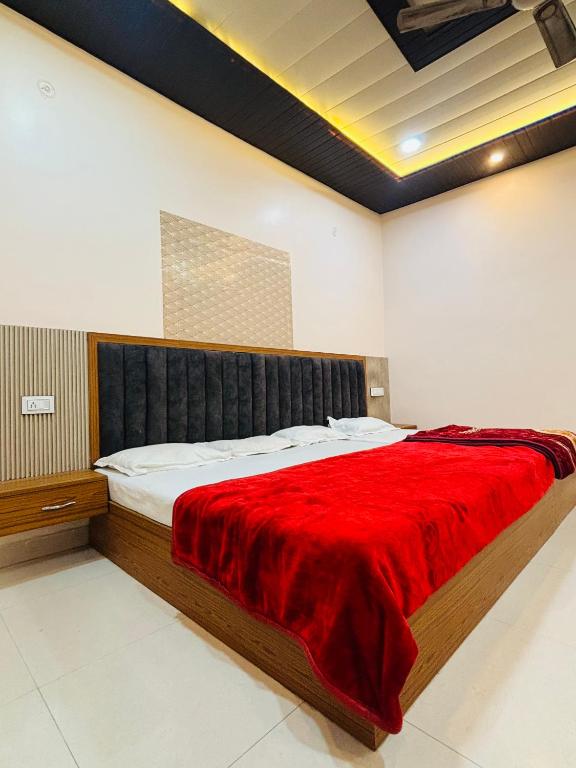 a bedroom with a large bed with a red blanket at Grihalaxmi Paying Guest House in Varanasi