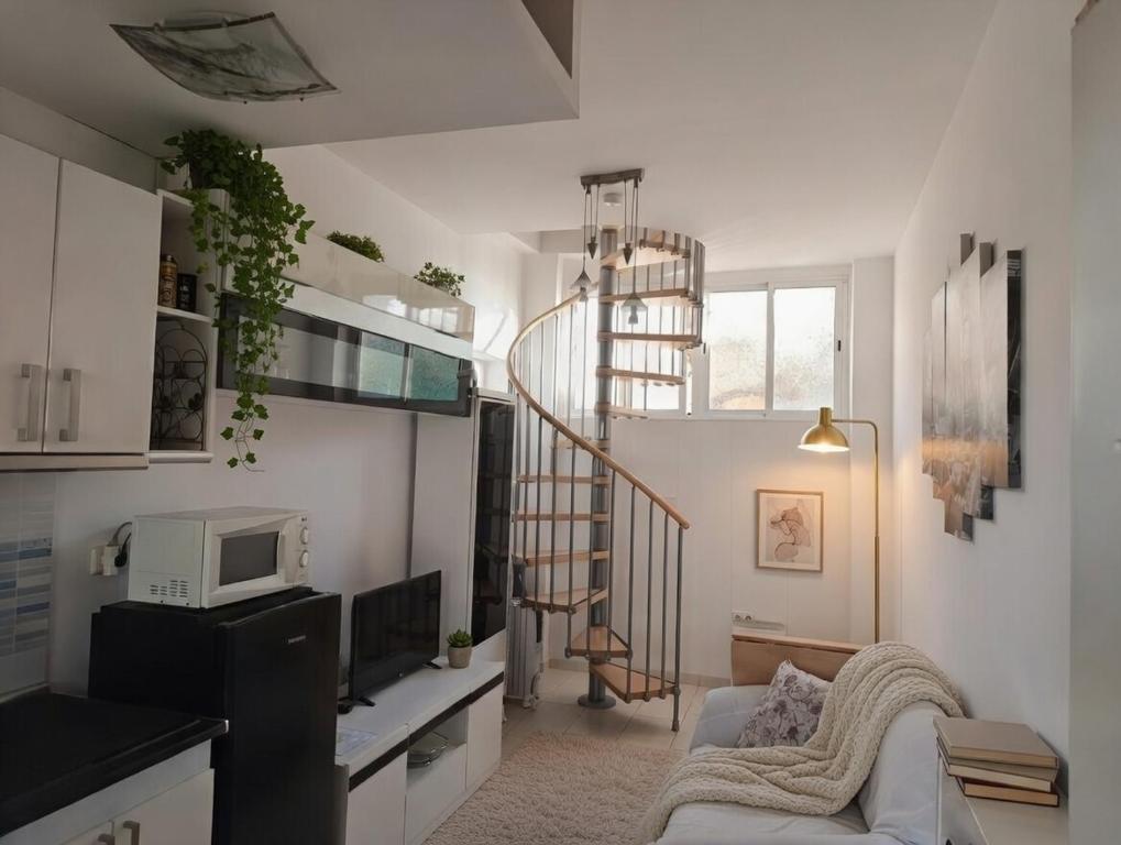 a living room with a spiral staircase in a room at Loft con encanto de Raúl y Rosa in San Sebastián de los Reyes