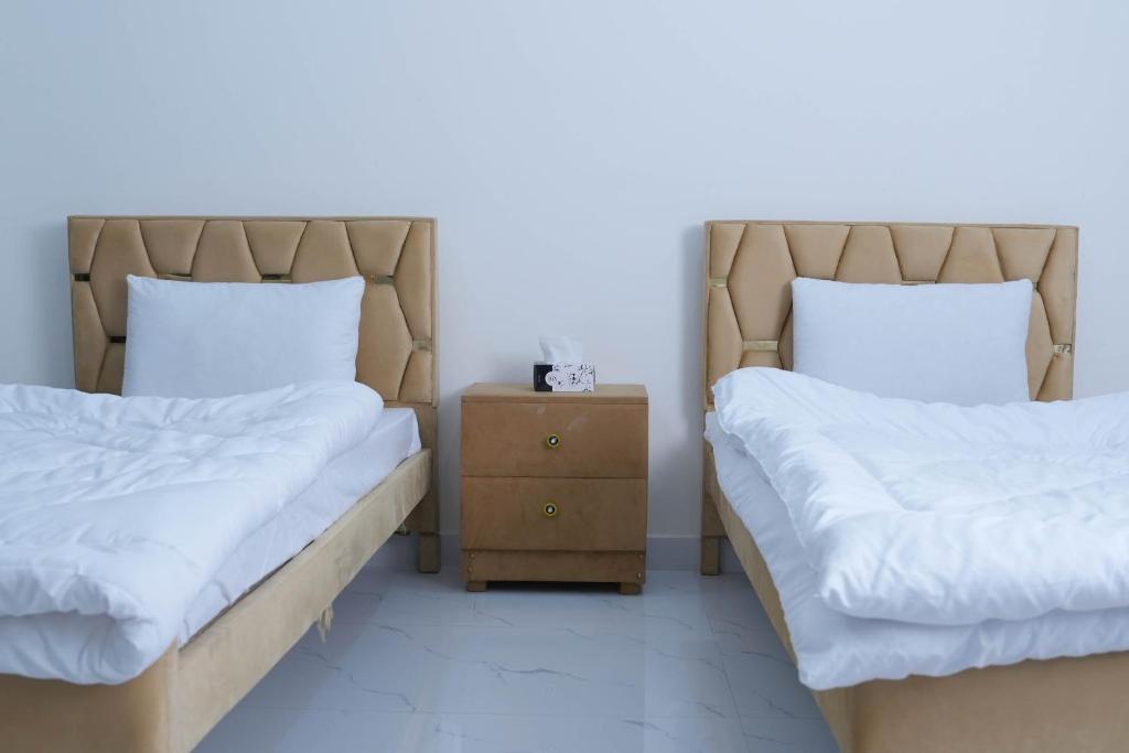 two beds sitting next to each other in a room at Zubi Guest House in Dargai