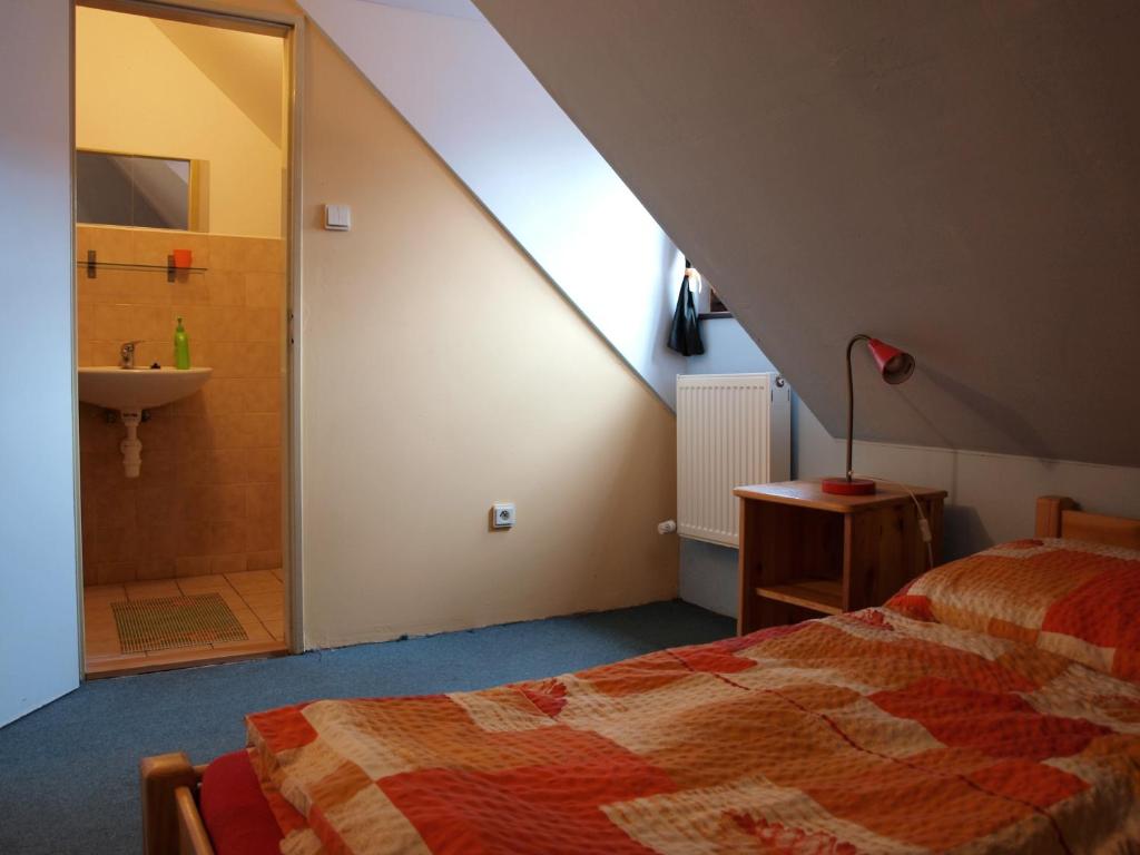 a bedroom with a bed and a bathroom with a sink at Hostel Skautský dom in Banská Štiavnica