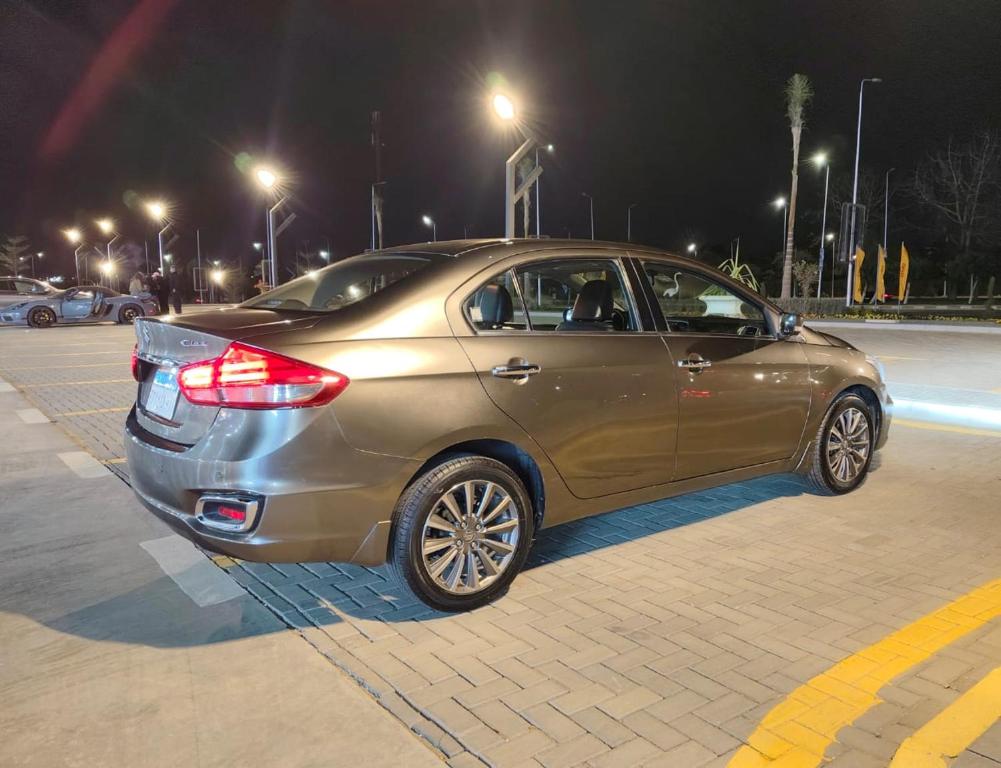 a gold car parked in a parking lot at night at private car in cairo in Asyut