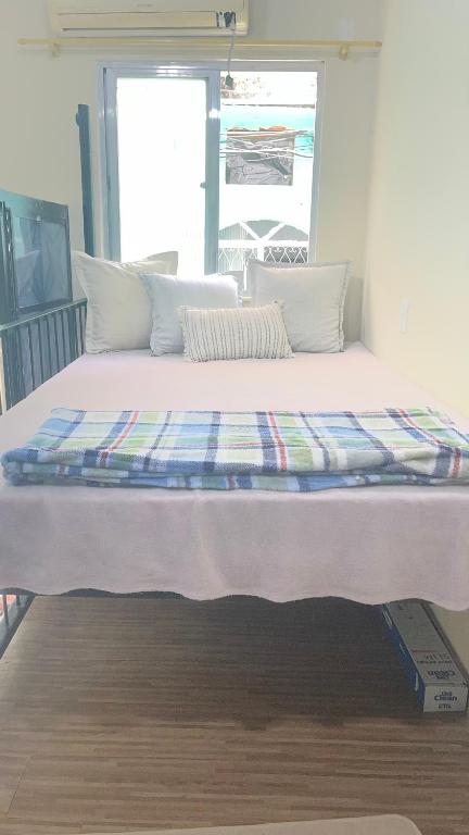 a large white bed in a room with a window at Na Ladeira Studio 01 Rua Miguel Rangel 660 casa 26 in Rio de Janeiro