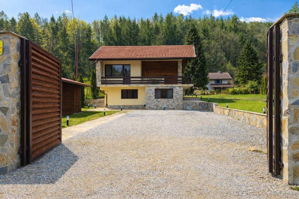 a driveway leading to a house with a garage at Къща за гости Гергана in Ribarica