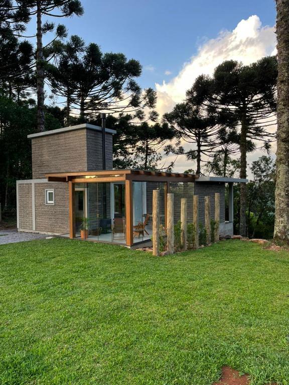 a modern house with a lawn in front of it at Refúgio das Araucárias in Nova Petrópolis
