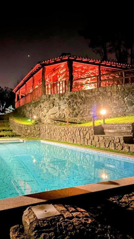a swimming pool in front of a building at night at Casa do Monte Sereno in Celorico de Basto