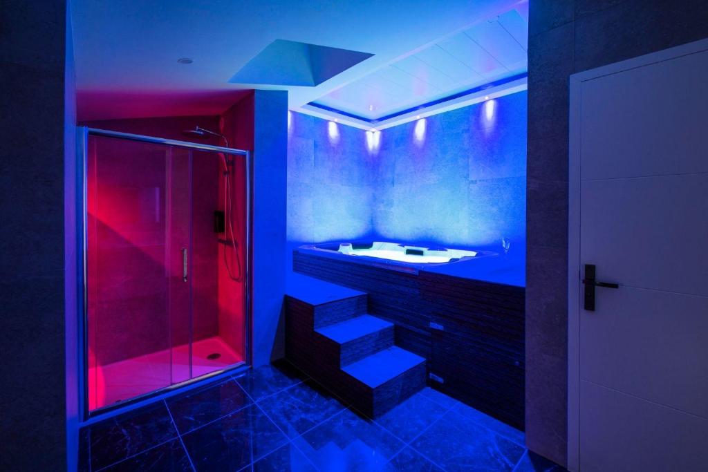 a bathroom with a sink and a shower with red lights at Hammam du château in Francheville
