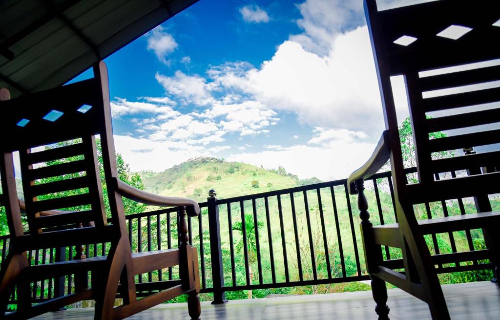 two chairs on a balcony with a view of a mountain at Ella Chalana Dew In in Ella