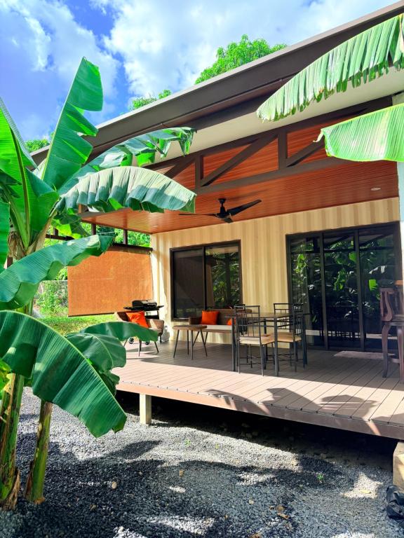 a house with a wooden deck with a table and chairs at M&M Container Home in Sardinal