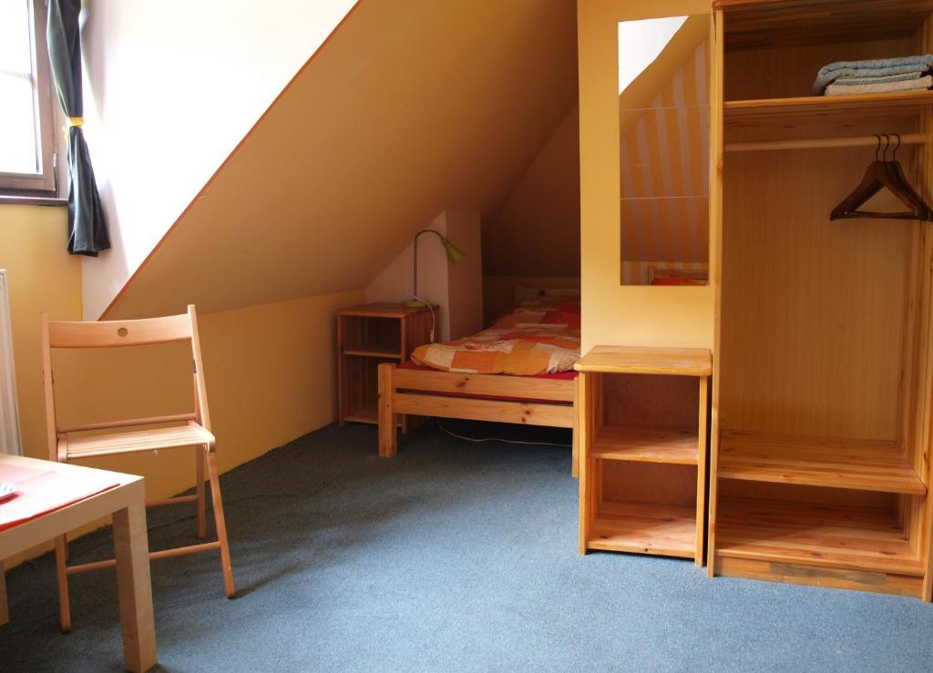 a attic room with a bed and bunk beds at Hostel Skautský dom in Banská Štiavnica
