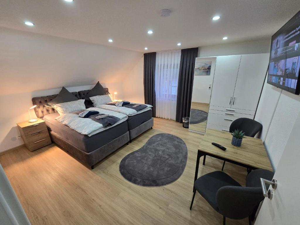 a bedroom with a large bed and a desk and a desk at Apartment an der Prims Nalbach in Nalbach