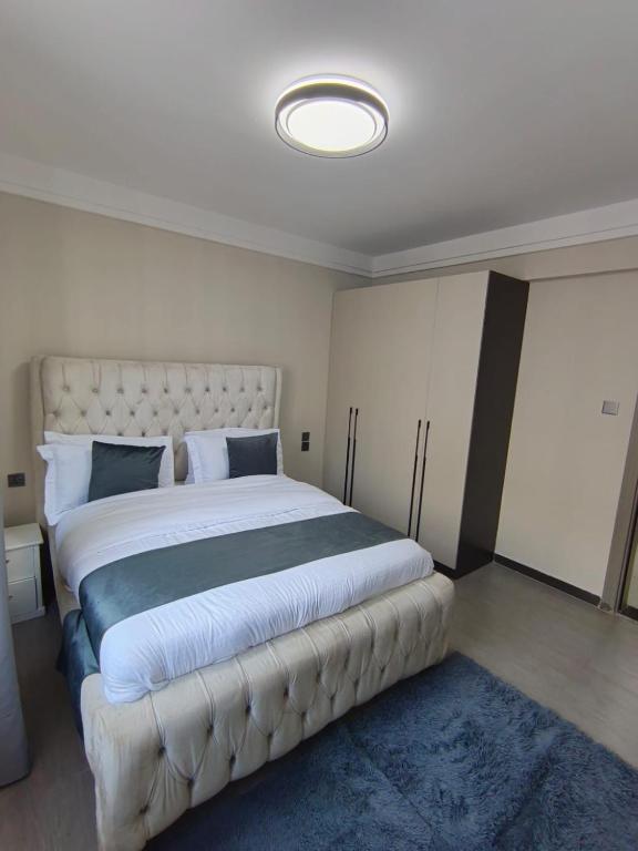 a bedroom with a large bed with a tufted headboard at Lyon in Nairobi