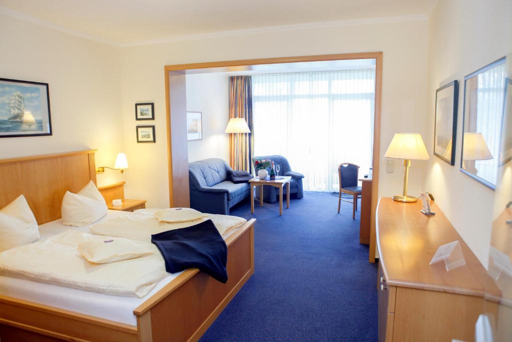 a hotel room with a bed and a living room at Hotel Mellum in Wangerland