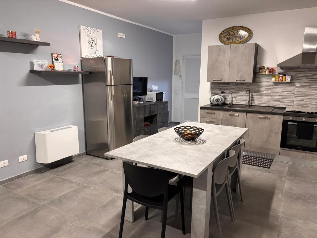 a kitchen with a table with chairs and a refrigerator at Home Sicilia in Carini