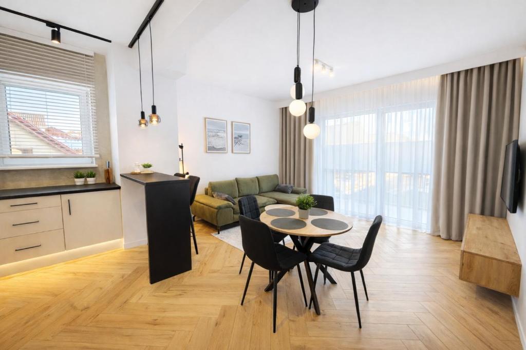 a kitchen and a living room with a table and chairs at Apartament Kaszubska Bryza III - HEL in Hel