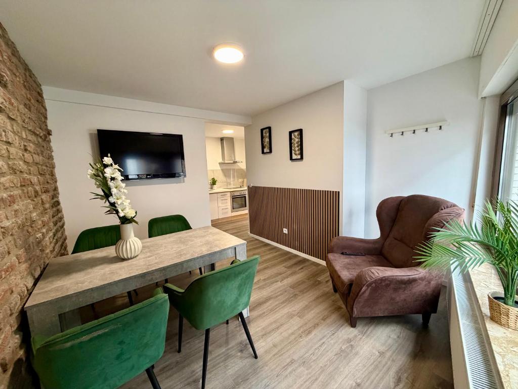 a living room with a table and chairs and a television at Apartment Mira 13 in Pulheim