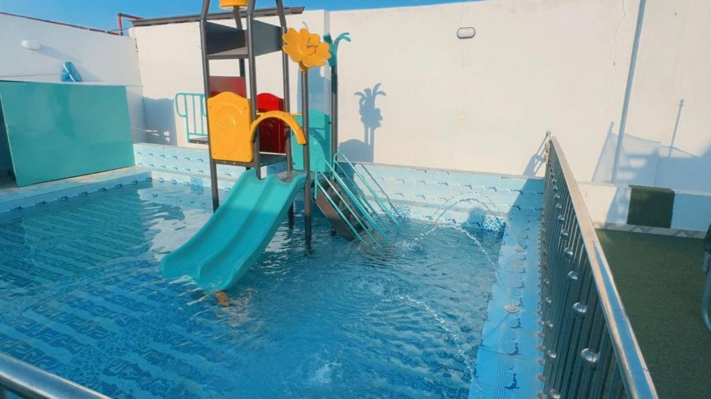 a swimming pool with a slide in the water at شاليهات تولين 2 in Taif