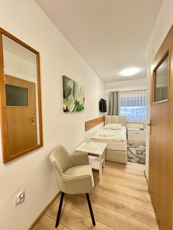 a room with a bed and a chair and a mirror at Motel Za Miedzą in Bralin