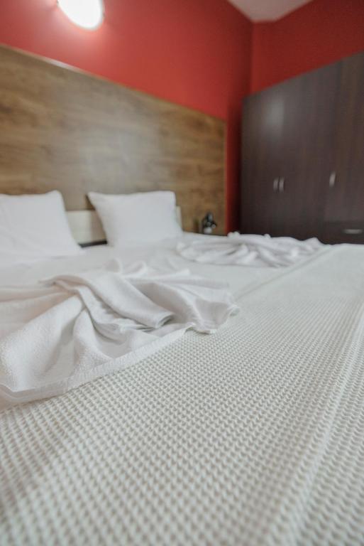 ein großes weißes Bett in einem Zimmer mit roten Wänden in der Unterkunft Trafi Em in Sofia