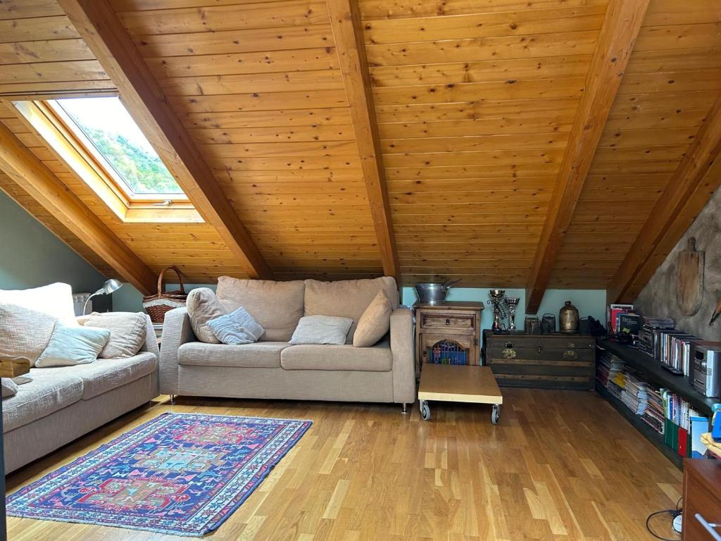 a living room with a couch and a wooden ceiling at Chalet Hoz de Jaca in Hoz de Jaca