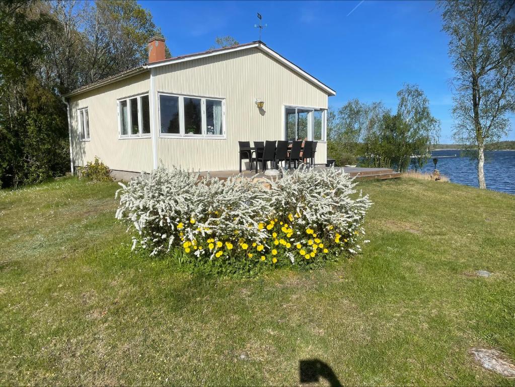 a house with a bunch of flowers in the yard at Sommarstuga med strandtomt in Ronneby