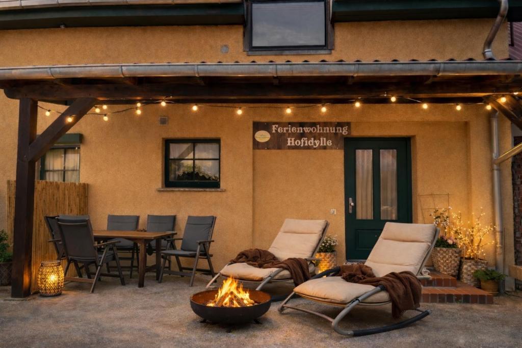 a patio with chairs and a fire pit in front of a building at Weidelandfarm am Riebener See in Beelitz