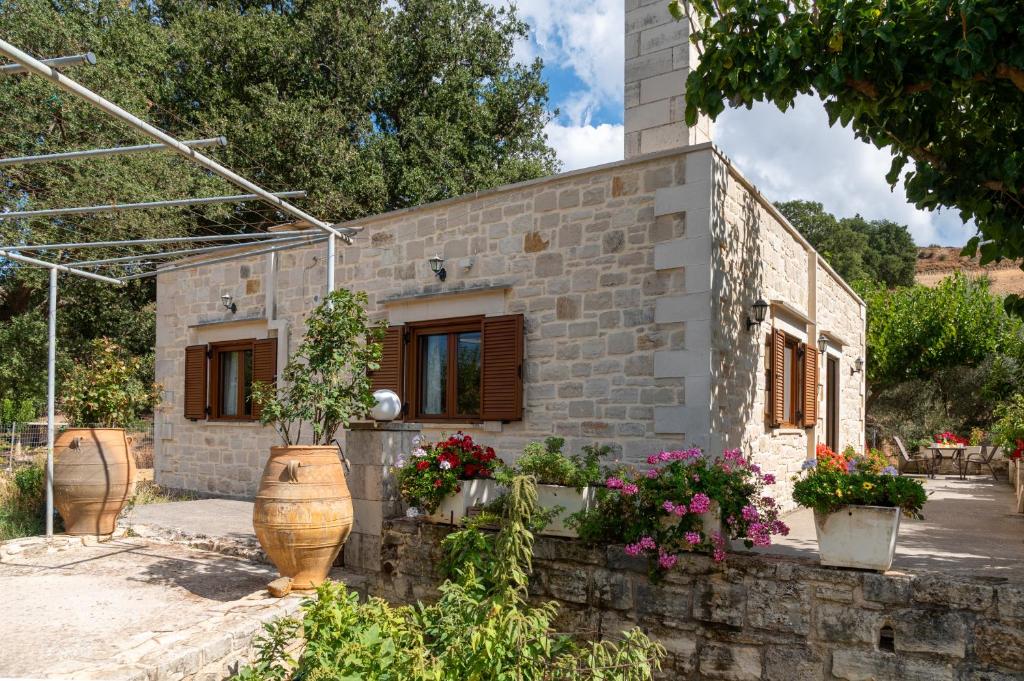 a brick house with flower pots in front of it at Drys Stone House in Miriokéfala