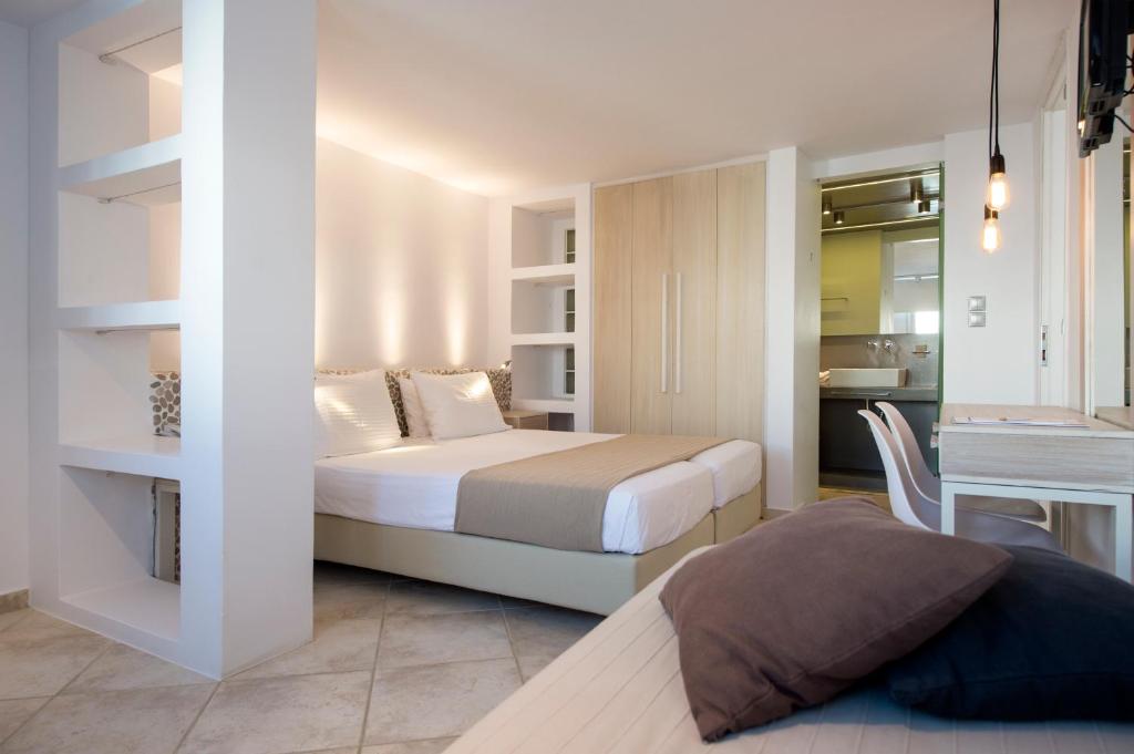 a small bedroom with a bed and a kitchen at Kanale's Rooms & Suites in Naousa