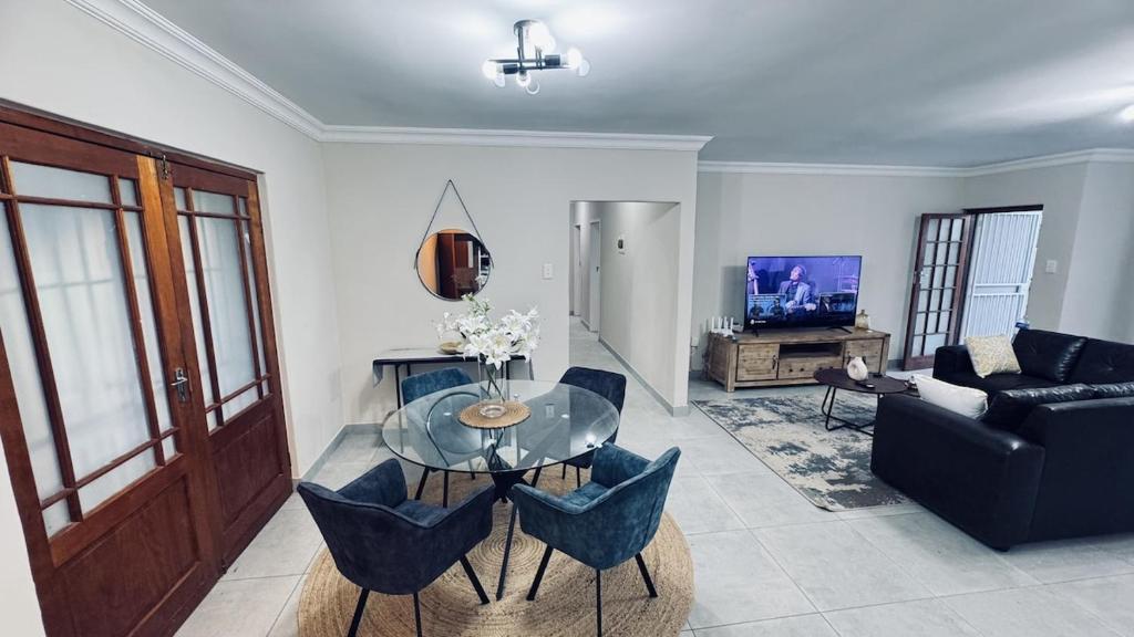 a living room with a glass table and a couch at Casa Tranquila Luxe in Pretoria