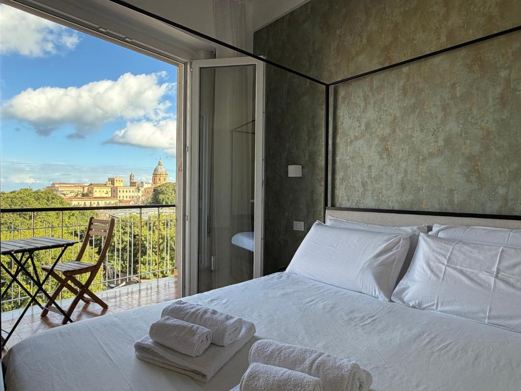 a bedroom with a bed and a balcony with a view at Cinquantotto Cozy Rooms in Palermo