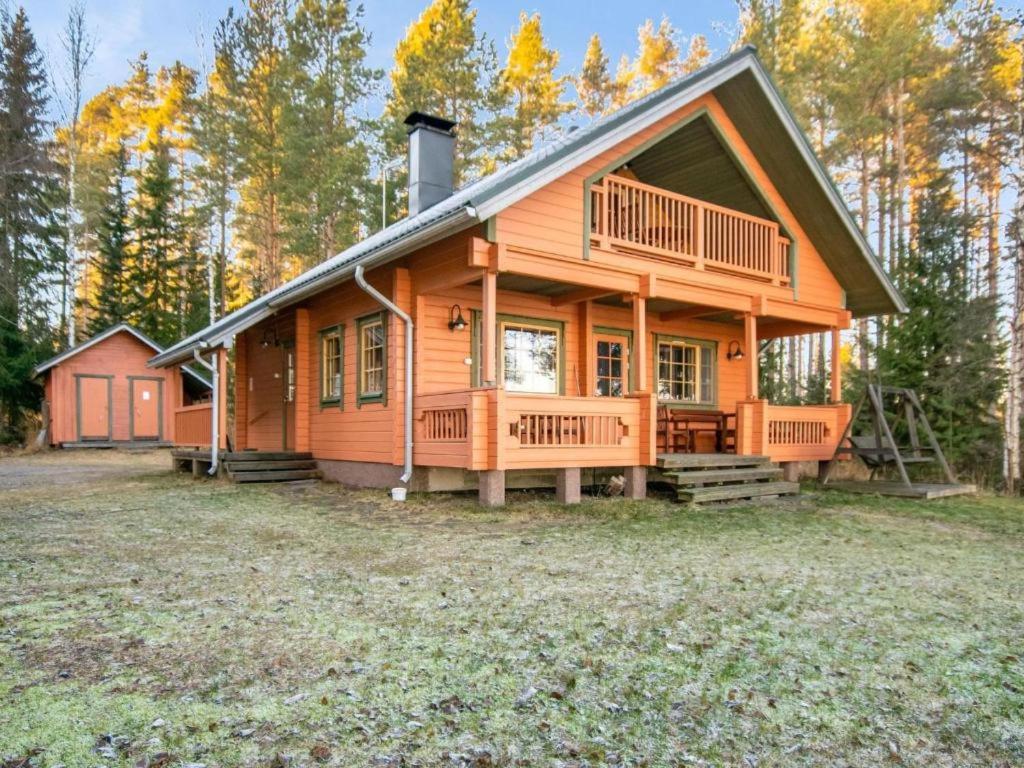 a large wooden house with a large yard at Tyyni Resort - Hirsihuvila Aalto in Liperi