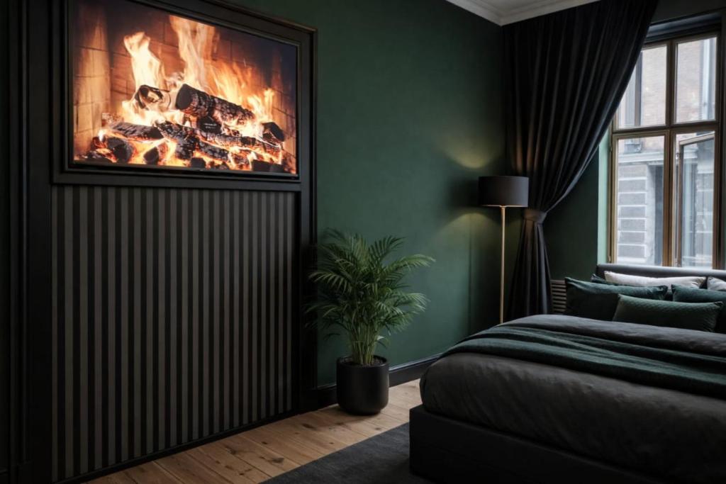 a bedroom with a bed and a fire in the wall at Greenbrook - Black Suite in Aalborg