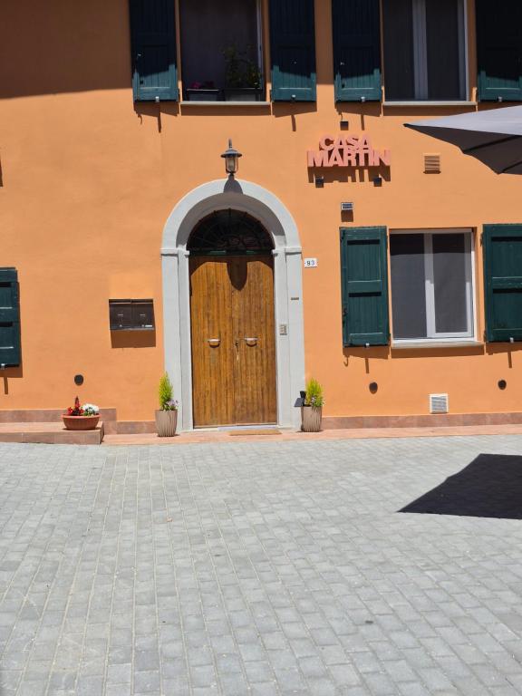 a building with a wooden door and green shutters at Casa Martin 2 in Tolè