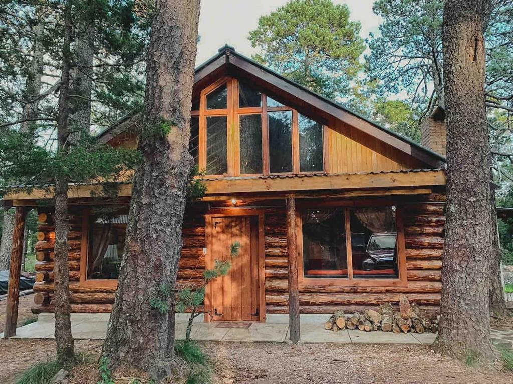 a log cabin in the woods with trees at Mexiquillo - La Fogata - Cabin #5 in La Ciudad