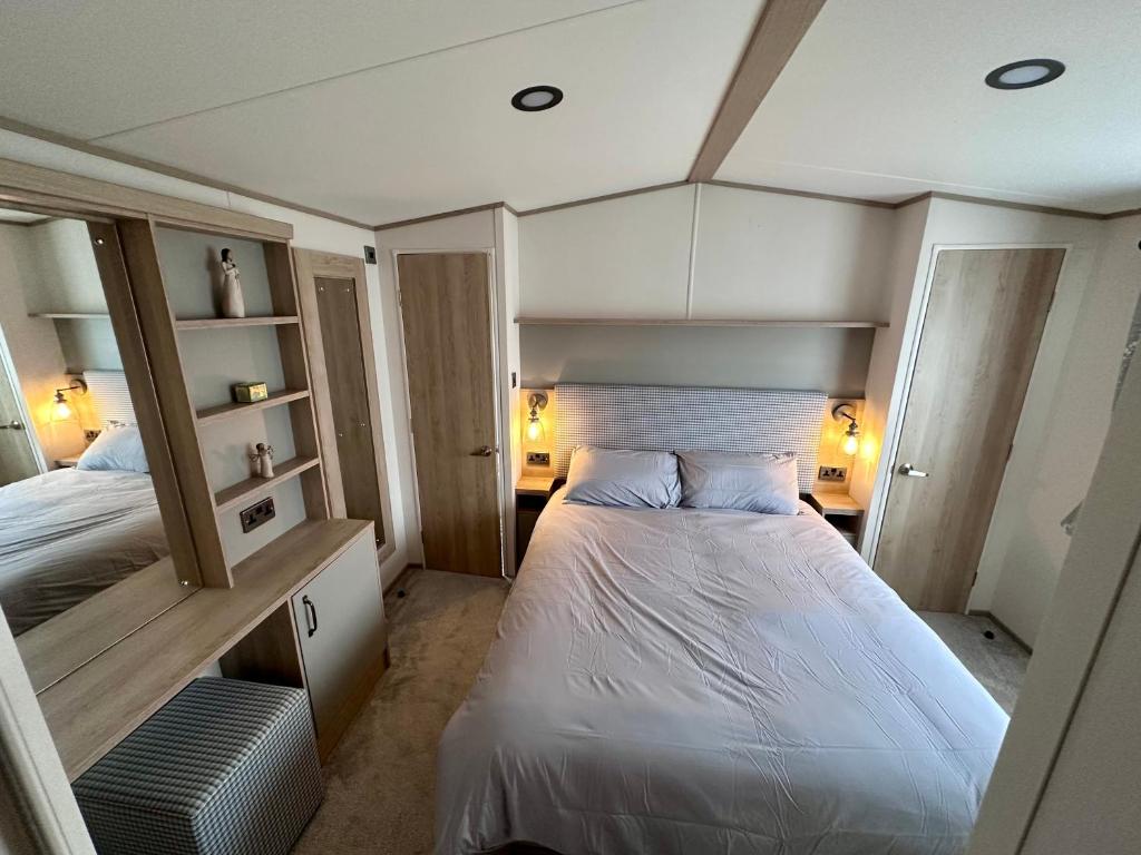 a small bedroom with a bed and a mirror at Blue dolphin static in Gristhorpe
