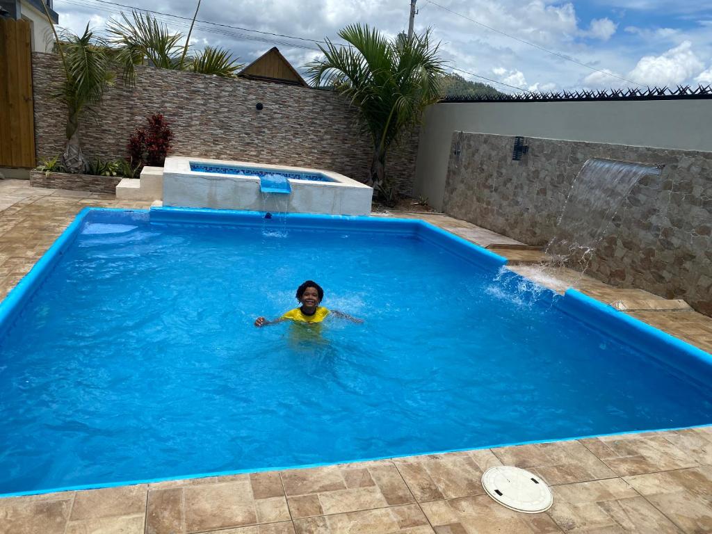 a child swimming in a swimming pool at VillaLunaCaridad in Jarabacoa