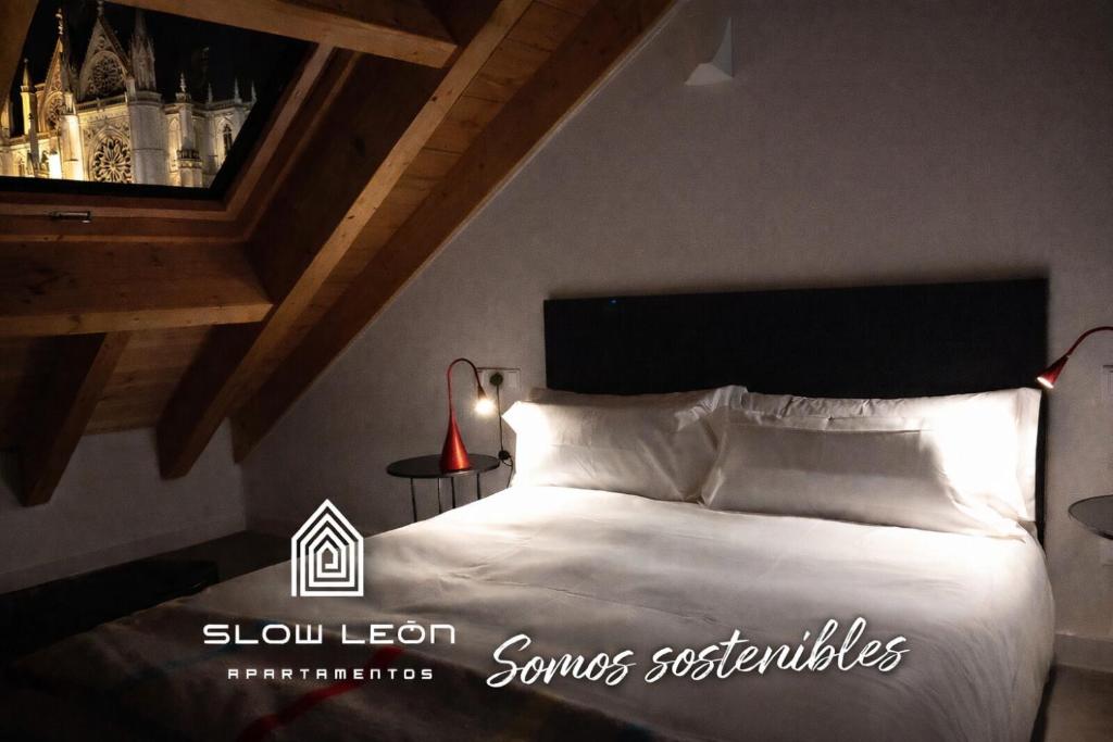 a bedroom with a white bed with a wine bottle shelf at Slow León Apartamentos Turísticos in León