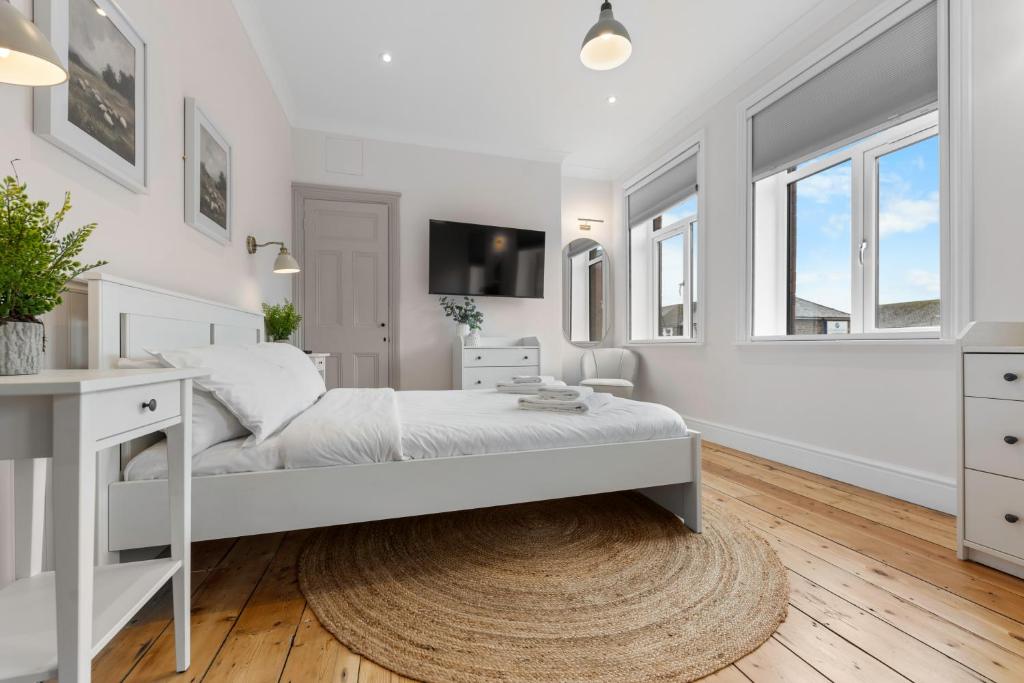 a white bedroom with a bed and a desk at Stunning Townhouse - 7 bedrooms - up to 18 Guests in Cardiff