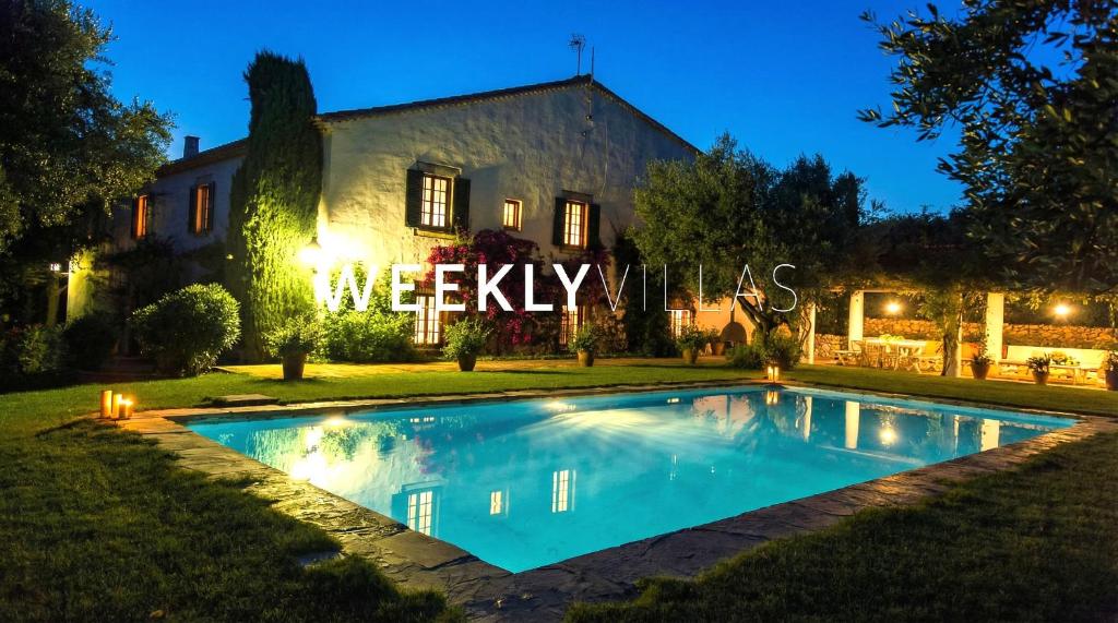 a house with a swimming pool in front of a building at Masia Sitges Mas Peirot Geniune Farmhouse 20 min walk from beaches 60 Heactares of Wine Fields Garden AC Until 18 people in Cubelles