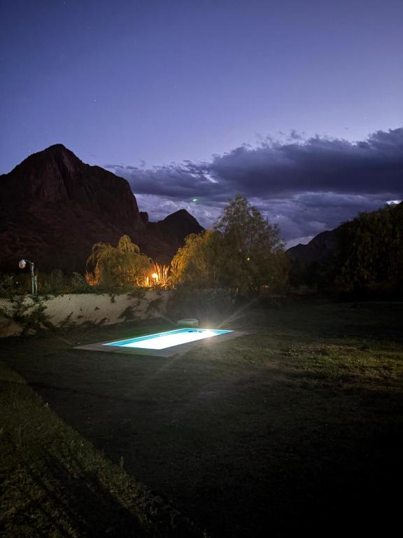 a pool with lights in a field at night at Cabaña La Verdicchio Privacidad y exclusividad Tu lugar de descanso in Valle Grande