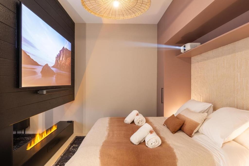 a bedroom with a bed with a flat screen tv at Host Inn Velvy Suite in Lyon