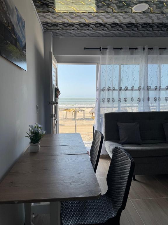 a dining table and chairs with a view of the beach at Apartamentos el mochilero frente al mar piso 2 apto 3 in Cartagena de Indias