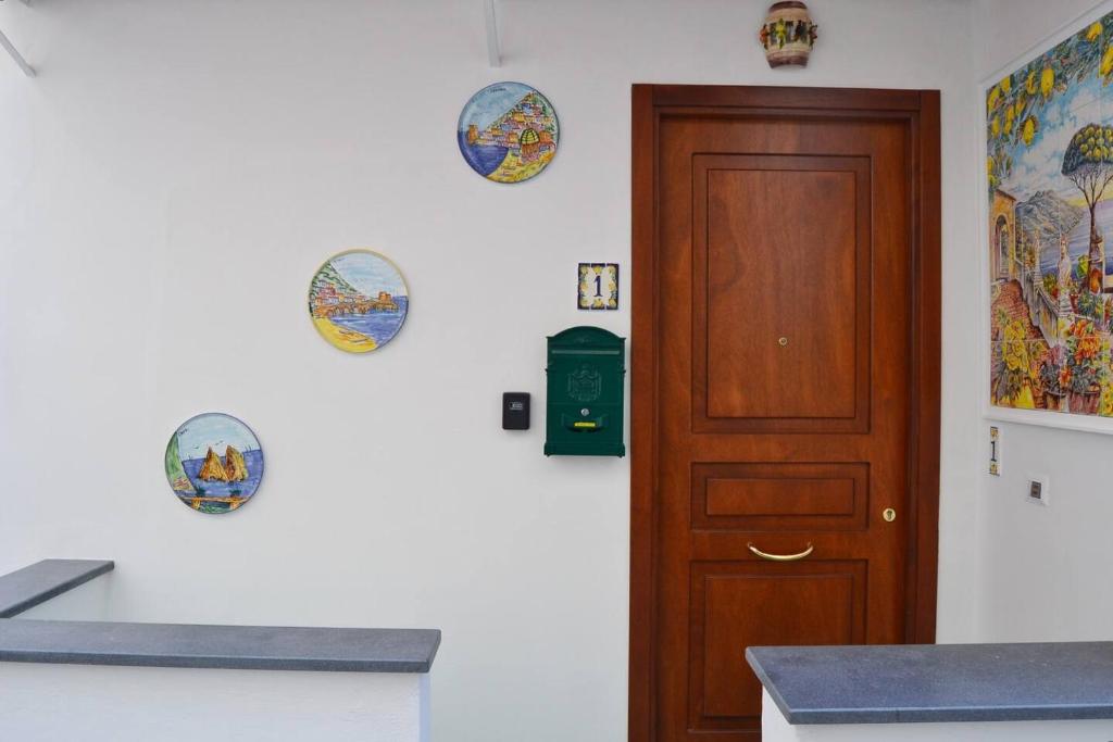 a kitchen with a wooden door and plates on the wall at Casa Bianca Amalfi New Central Apt in Amalfi