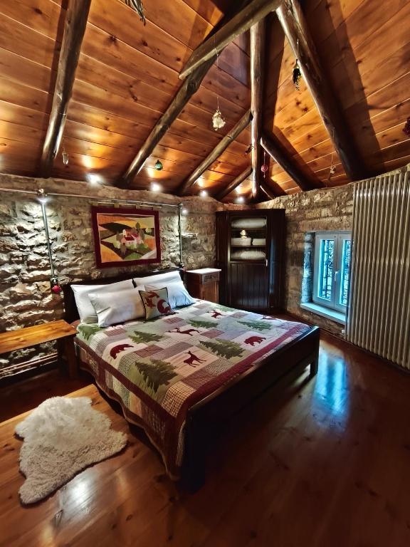 a bedroom with a bed and a wooden ceiling at HerbStone Lodges in Asprangeloi