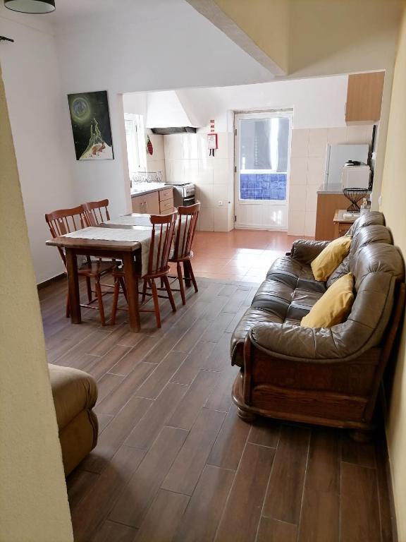 a living room with a leather couch and a table at Casa das 4 estações in Castelo Branco