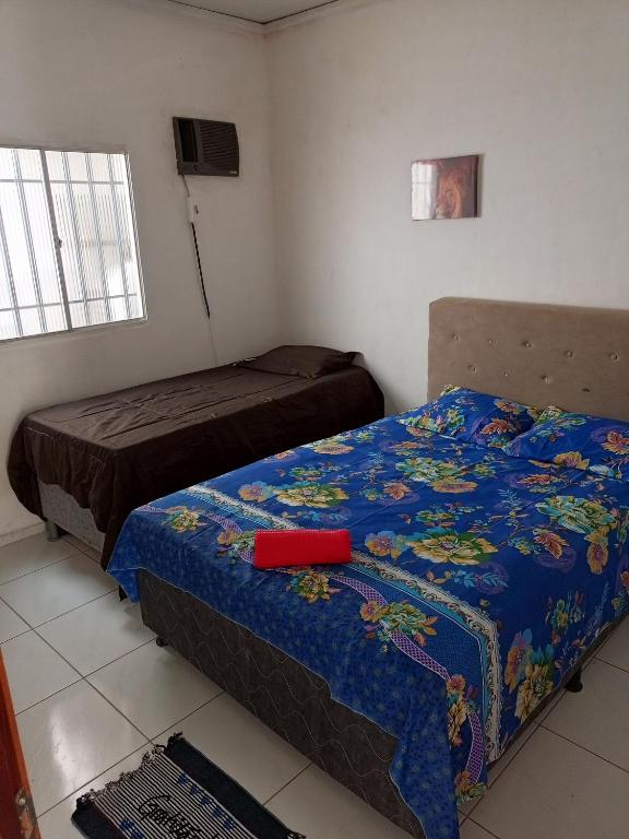a bedroom with two beds with a blue comforter at Casa mobiliada 2 Com 4 camas e 2 quartos com ar condicionado in Juazeiro do Norte