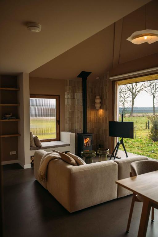 a living room with a couch and a fireplace at Gastenverblijf Buitenhoudt in Vinkel