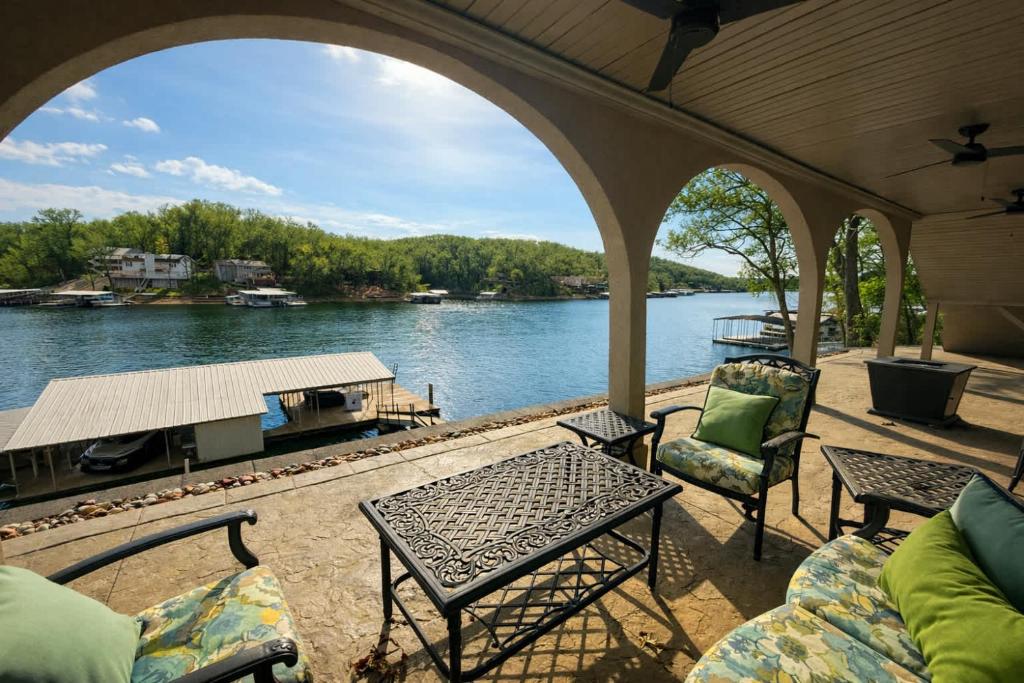 a patio with chairs and a table and a view of a river at Mimosa Mornings Home for 12 in Rocky Mount